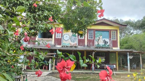 a house with red flowers in front of it at Tahan Guest House in Kuala Tahan