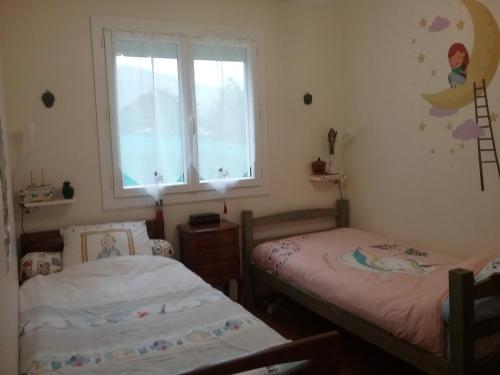 dwa łóżka pojedyncze w pokoju z oknem w obiekcie les petites roches w mieście Saint-Fortunat-sur-Eyrieux