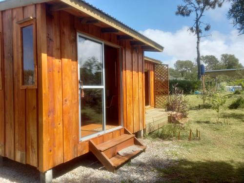 Cabaña de madera con ventana grande en un campo en Verde viento, en La Paloma