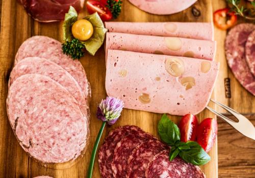 a wooden table with meats and vegetables on it at Hotel Rappenhof in Breuna