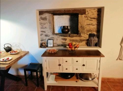 una cocina con una barra con un bol de fruta. en Casa de piedra en pequeña aldea de Ortigueira, 