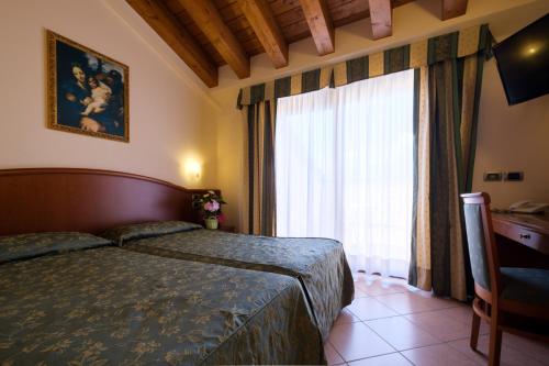 a bedroom with a bed and a large window at Garda Family House in Brenzone sul Garda