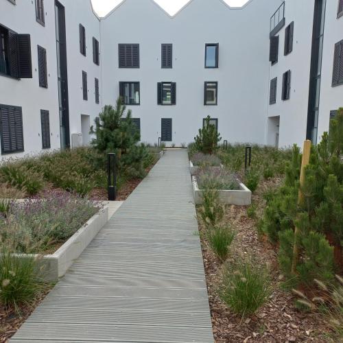 a wooden walkway in front of a building at Apartament Orlando w Porto Łeba 350m od morza in Łeba