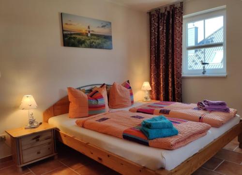 een slaapkamer met een bed met kleurrijke kussens en een raam bij Ferienwohnung Ostseezeit - in ruhiger Lage in Nienhagen