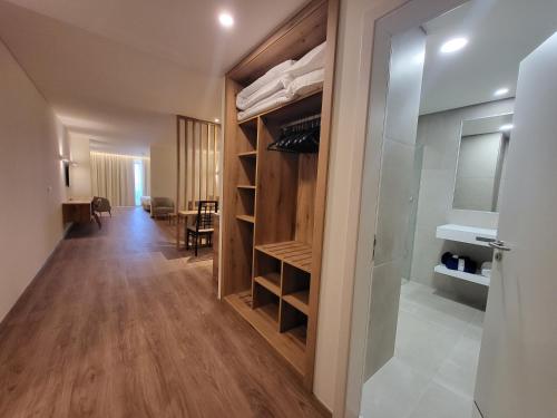 um quarto com um armário com prateleiras de madeira em Hotel Royal Orchid no Caniço