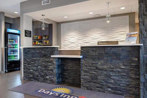 a bar in a restaurant with a stone wall at Days Inn & Suites by Wyndham Warman in Warman