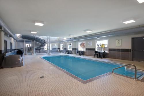 a large swimming pool in a hotel room at Days Inn & Suites by Wyndham Warman in Warman