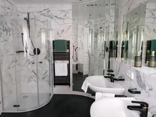 a bathroom with a shower and a sink and a tub at Privathaus Achensee in Achenkirch