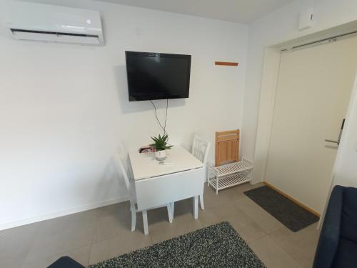a living room with a white table and a tv on a wall at Hagavik 8 in Växjö