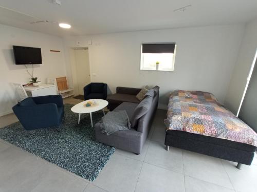 uma sala de estar com um sofá, uma cama e uma mesa em Hagavik 8 em Växjö