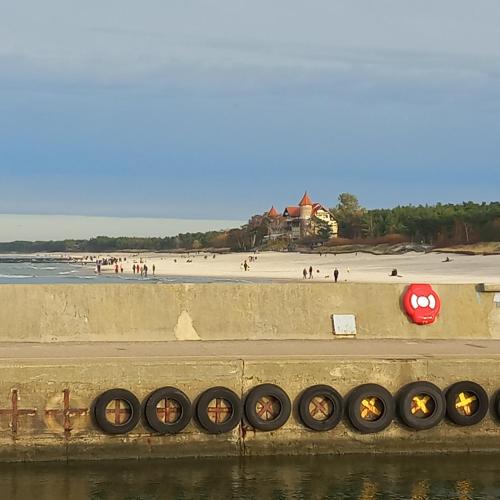 a beach with a row of tires on a wall at Apartament Orlando w Porto Łeba 350m od morza in Łeba