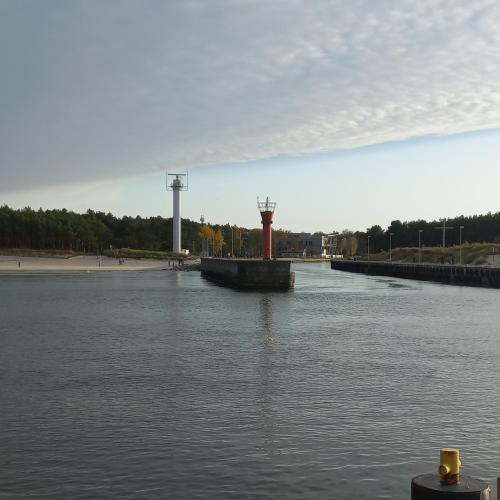 a large body of water with a lighthouse in the middle at Apartament Orlando w Porto Łeba 350m od morza in Łeba