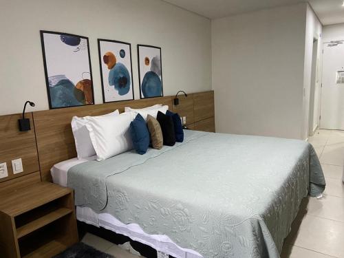 a bedroom with a bed with blue and white pillows at Flat Aconchegante - Granja Brasil Resort - Itaipava in Petrópolis