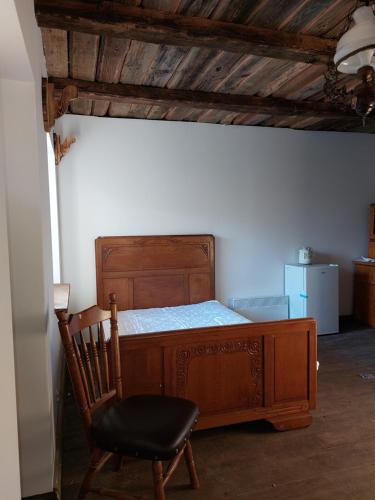 a bedroom with a wooden bed and a chair at Agroturystyka LipoweWzgórze- Jaś&Małgosia in Tereszpol