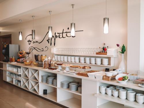 una panadería con estanterías blancas llenas de comida en Hotel Leone, en Međugorje