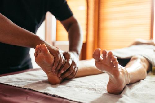 a person getting a foot massage on a bed at Wellnesshotel ...liebes Rot-Flüh in Haldensee