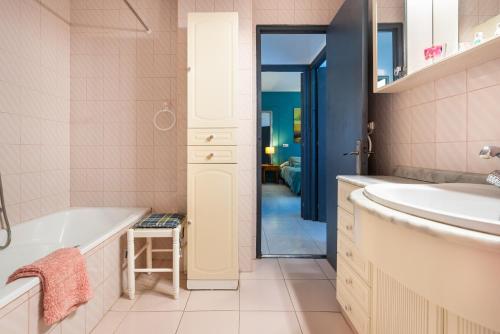 La salle de bains est pourvue d'une baignoire, d'un lavabo et d'un miroir. dans l'établissement 4 bedr groundfl apartm 60m beach, à Torremolinos