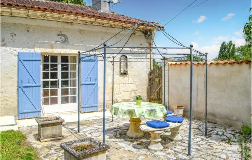 un patio avec une table et des chaises devant une maison dans l'établissement Nice Home In Bourg Du Bost With Wifi, à Bourg-du-Bost