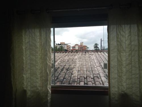 a window with a view of a brick road at Apts centro Ubatuba in Ubatuba