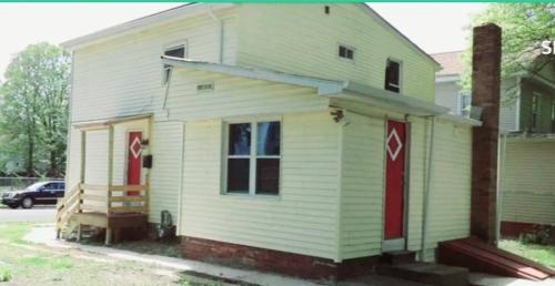 una pequeña casa blanca con puertas rojas en una calle en Room in Guest room - Black-white Rm By Yale U, en New Haven