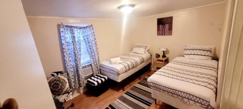 1 dormitorio con 2 camas y ventana en Room in Guest room - Black-white Rm By Yale U, en New Haven