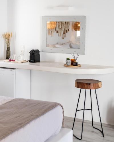 a white bedroom with a bed and a mirror at Tagoo Studios Mykonos in Mýkonos City