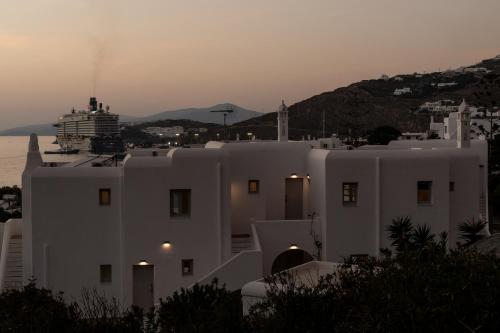 a white building with a cruise ship in the background at Tagoo Studios Mykonos in Mýkonos City