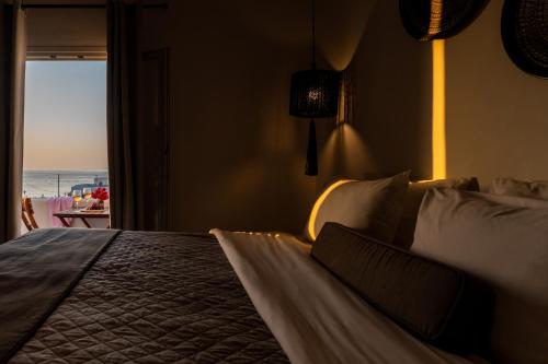 a bedroom with a bed with a view of the ocean at Tagoo Studios Mykonos in Mýkonos City