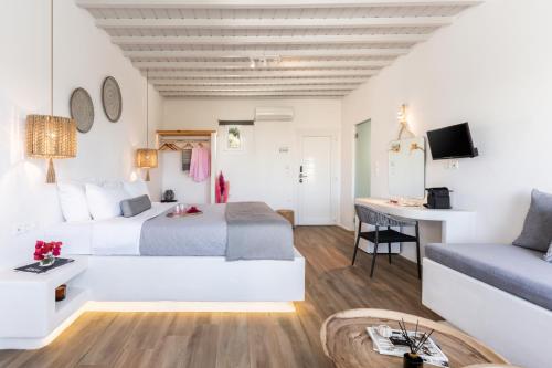 a hotel room with a bed and a desk at Tagoo Studios Mykonos in Mýkonos City