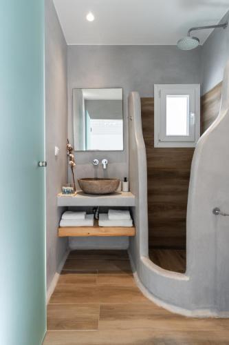 a bathroom with a sink and a mirror at Tagoo Studios Mykonos in Mýkonos City