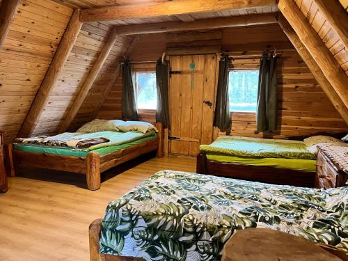 um quarto com três camas num chalé de madeira em Domwigierski pl -Tobołowo GR -nad samym brzegiem jeziora z sauną- klimatyzacja em Tobołowo