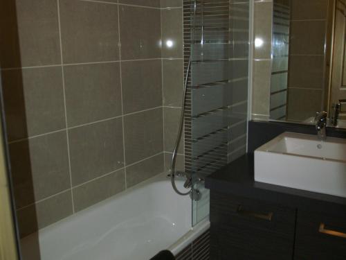 a bathroom with a bath tub and a sink at Appartement haut de gamme 3P cabine, pied des pistes, balcon, parking, centre station à 150m - FR-1-557-15 in Les Adrets