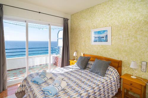 Un dormitorio con una cama con vista al mar. en Apto en Primera Línea Arenal Calpe, en Calpe