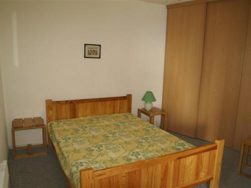 - une chambre avec un lit doté d'un cadre de lit en bois dans l'établissement 3 pièces au pied des pistes avec balcon et casier à skis - FR-1-557-7, à Les Adrets