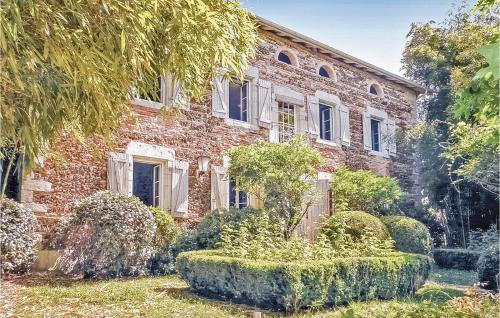 an old brick house with bushes in front of it at 3 Bedroom Gorgeous Home In Arjuzanx in Arjuzanx