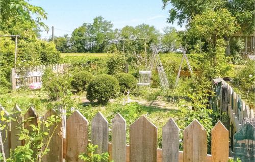 a garden with a wooden fence in front of a yard at 3 Bedroom Gorgeous Home In Arjuzanx in Arjuzanx