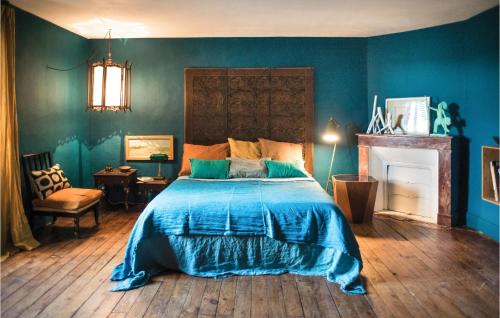a blue bedroom with a bed and a fireplace at 3 Bedroom Gorgeous Home In Arjuzanx in Arjuzanx