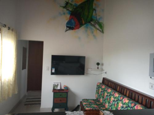 a living room with a couch and a tv on the wall at Apts centro Ubatuba in Ubatuba