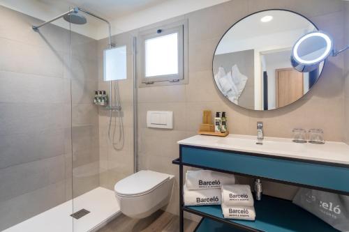 W łazience znajduje się toaleta, umywalka i lustro. w obiekcie Barceló Fuerteventura Royal Level - Adults Only w mieście Caleta De Fuste