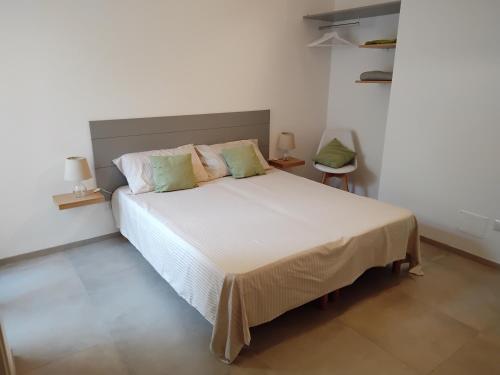 a bedroom with a large white bed with green pillows at B&B Corso Trieste e Trento in Alberobello