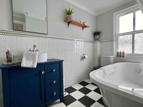 y baño con bañera blanca, lavamanos y bañera. en Cosy Georgian Cottage - Parking - Central Frome, en Frome