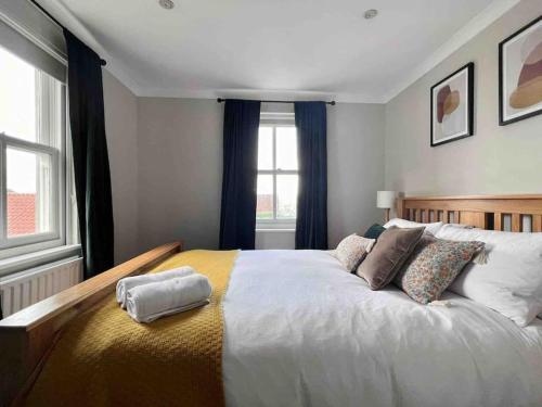 um quarto com uma grande cama branca com almofadas em Cosy Georgian Cottage - Parking - Central Frome em Frome