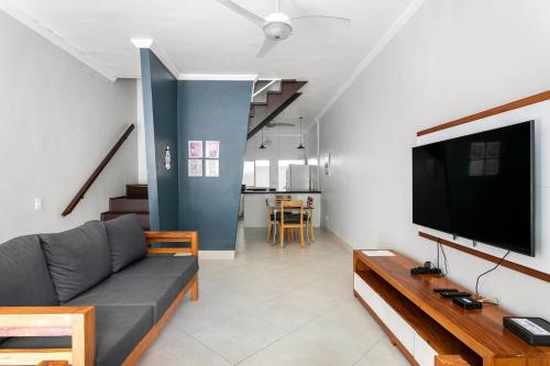 sala de estar con sofá y TV de pantalla plana en Juquehy - Casa Espaçosa em Condomínio en Juquei