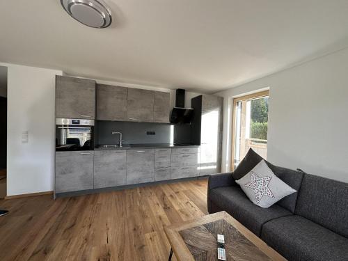 a living room with a couch and a kitchen at Appart Anna in Scheffau am Wilden Kaiser