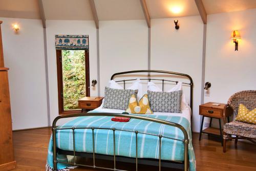 1 dormitorio con cama y ventana en Finest Retreats - Woodpecker Luxury Treehouse Hideaway en Dittisham