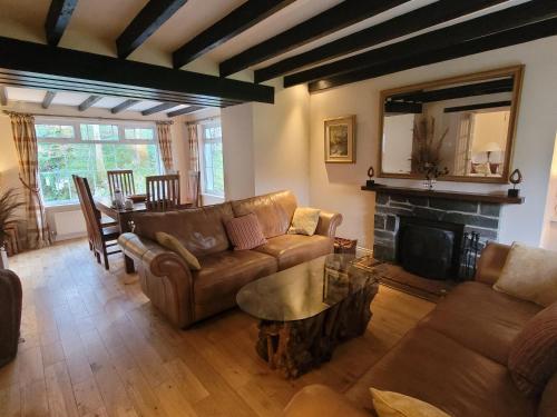 a living room with a couch and a fireplace at Dubh Loch Cottage in Rowardennan