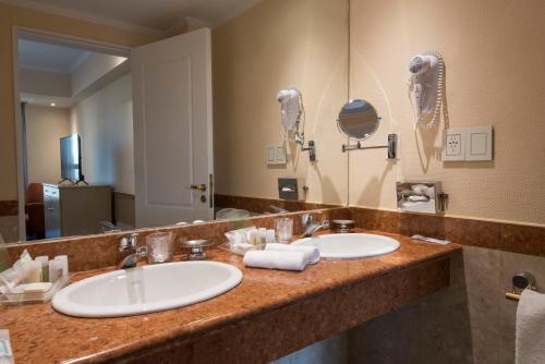 a bathroom with two sinks and a large mirror at Holiday Inn Cordoba, an IHG Hotel in Cordoba