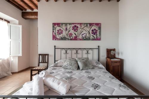 a bedroom with a bed and a painting on the wall at Fattoria il Casone in Monteriggioni