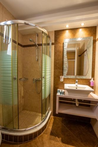 ein Badezimmer mit Dusche und Waschbecken in der Unterkunft Irini Hotel in Afiartis