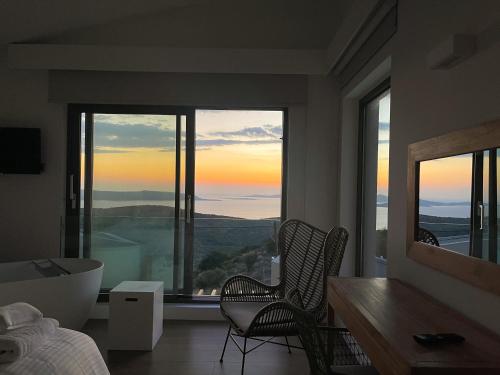 a bedroom with a large window with a tub and a view at Dimeli - Sea View Villas in Foinikounta in Finikounta